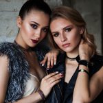 Close Up of 2 Stylish Female Models Posing by Concete Wall