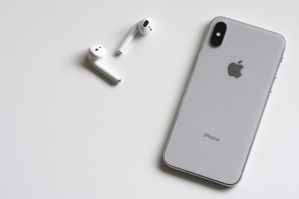 Silver iPhone X with Airpods on White Background